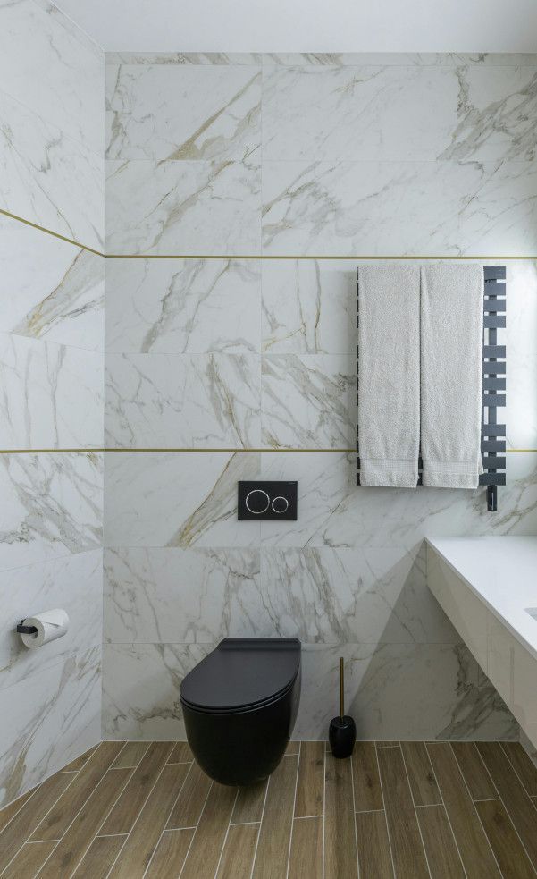 Bathroom tiled in polished white marble for a sleek and bright look.